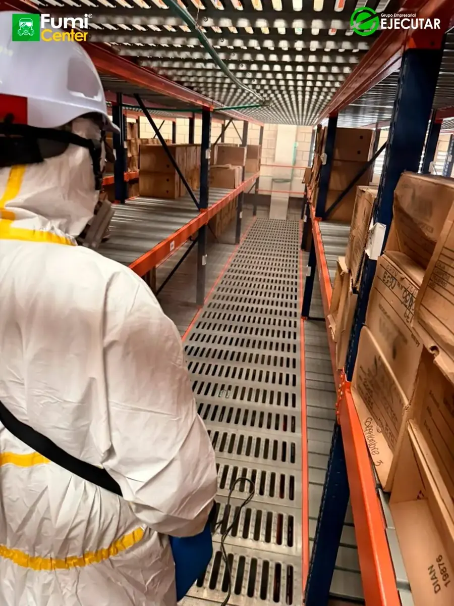 Técnico de FumiCenter con traje de protección aplicando en oficinas y áreas técnicas de la DIAN en Santa Marta