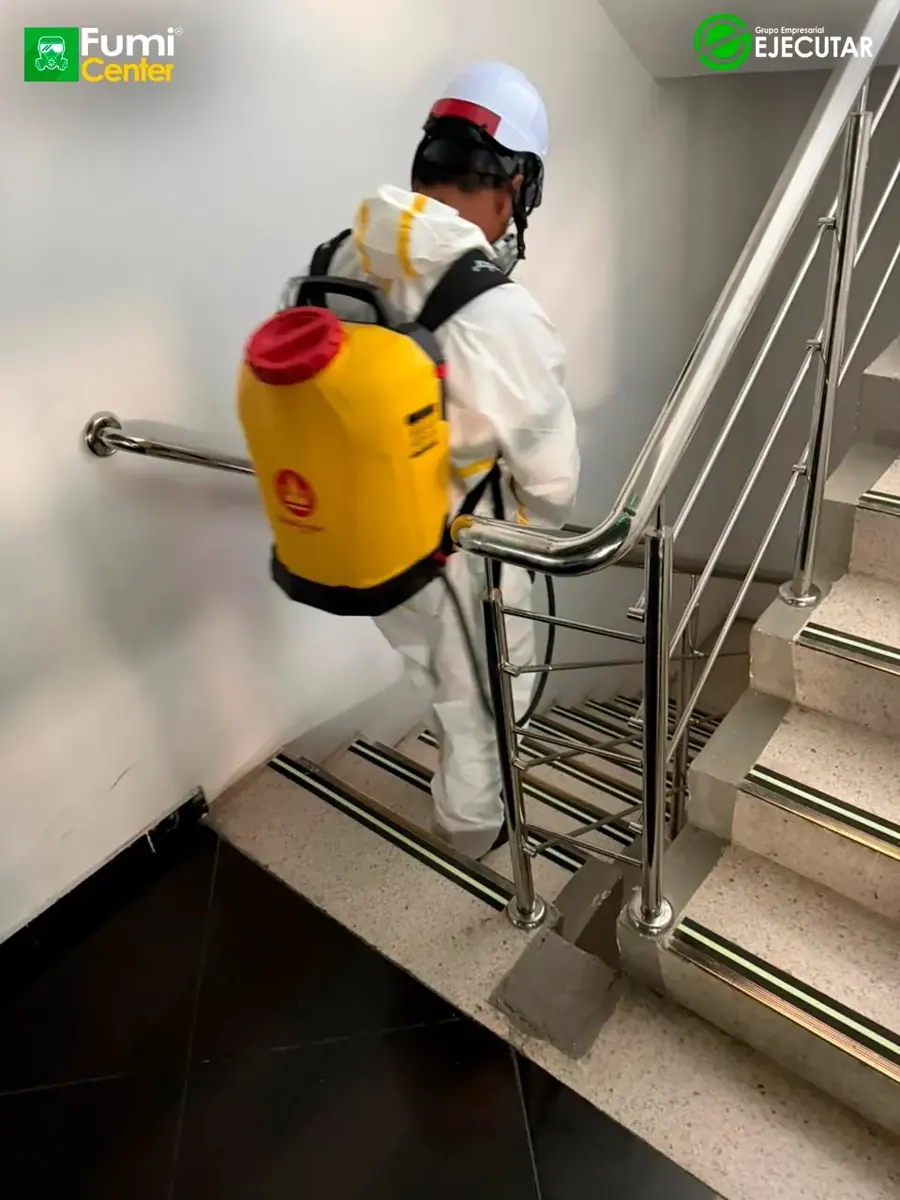 Técnico de FumiCenter con traje de protección aplicando en oficinas y áreas técnicas de la DIAN en Santa Marta